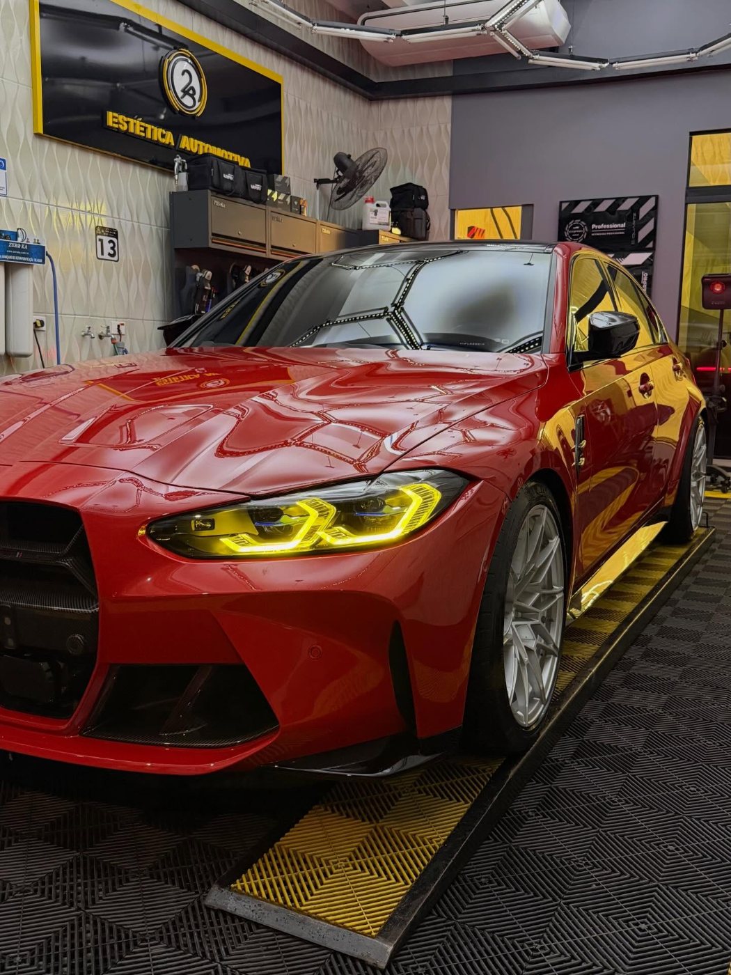 BMW M3 vermelha com faróis acesos