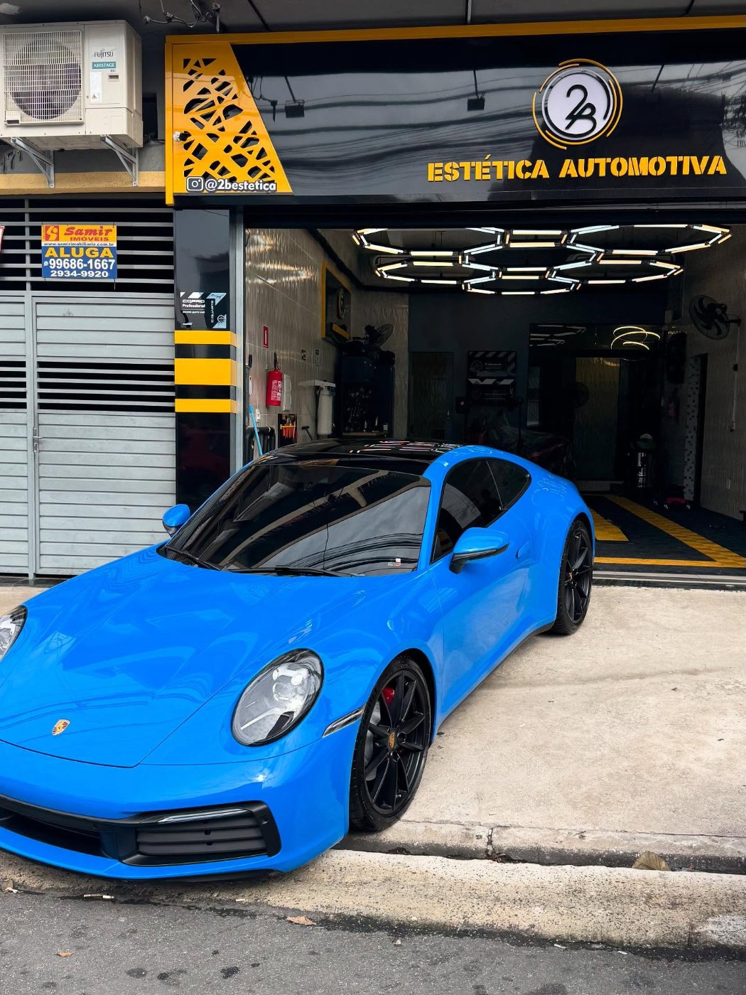 Fachada da 2B Estética Automotiva com um Porsche 911 azul na entrada