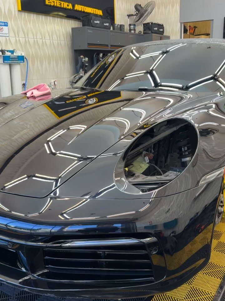 Porsche 911 preto com reflexo das luzes hexagonais no capô